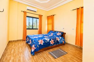 a bedroom with a bed with a blue comforter at Résidence APOW in Agogoudjou