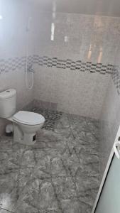 a bathroom with a toilet and a tiled floor at Appartement kantaoui in Sousse +4 photos