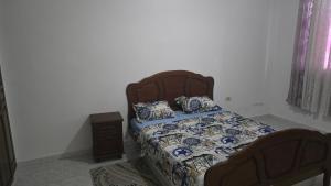a bedroom with a bed and a night stand at Appartement kantaoui in Sousse