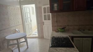 a kitchen with a stove top oven next to a door at Appartement kantaoui in Sousse