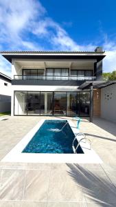 a house with a swimming pool in front of it at Casa 03 suites Maragogi Japaratinga in Japaratinga
