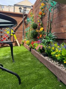 a garden with flowers and a chair in the grass at Blackpool cosy cottage in Blackpool