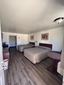 a hotel room with two beds and a table at Shady Motel in Caliente