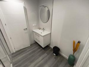 a white bathroom with a sink and a mirror at Xeliña B in A Estrada +5 photos