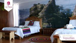 a bedroom with two beds and a mountain mural at Suites Las Plazas in Cuernavaca