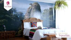 a bedroom with a wall mural of a mountain at Suites Las Plazas in Cuernavaca