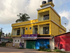 a yellow building with a tower on top of it at Golden rays beach stay in Mangalore