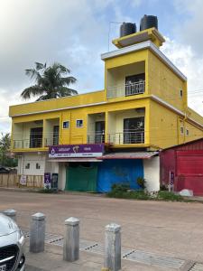 a yellow building with a balcony on top of it at Golden rays beach stay in Mangalore +5 photos