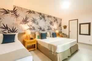 a bedroom with two beds and a wall with plants at Armação Resort Porto de Galinhas in Porto De Galinhas +93 photos