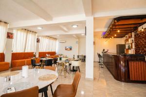 a restaurant with tables and chairs and a bar at Résidence APOW in Agogoudjou