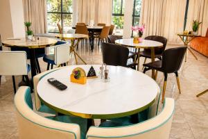 a dining room with tables and chairs and a room with windows at Résidence APOW in Agogoudjou +22 photos