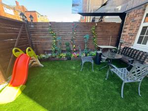a backyard with a playground with a table and a slide at Blackpool cosy cottage in Blackpool