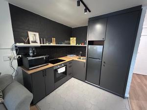 a kitchen with black walls and a counter with a refrigerator at Greenpoint Chic Studio Apartment in Cape Town