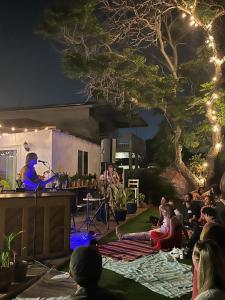 a crowd of people sitting on the grass watching a band on a stage at Casa Sur in Chula Vista