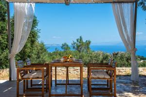 a table and chairs with a view of the ocean at Amaranthus house in Longós +12 photos