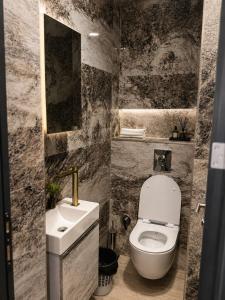 a bathroom with a white toilet and a sink at Grand Clochē in Ulcinj +42 photos