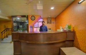 a man standing behind a bar in a restaurant at Hotel Shaan- M I Road City Centre in Jaipur