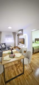 a living room with a table and a couch at Apartman Doboj in Doboj +11 photos