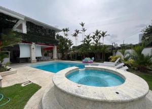 a swimming pool in a yard with chairs and a house at Mansión Versace in Panama City