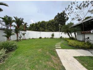 a yard with a white fence and palm trees at Mansión Versace in Panama City