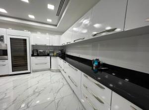 a large white kitchen with white cabinets and appliances at Mansión Versace in Panama City