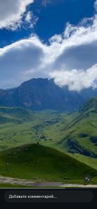 a green field with a mountain in the background at Gusar House in Qusar