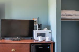a tv and a microwave on top of a dresser at Bouctouche Bay Inn in Bouctouche