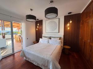 a bedroom with a bed with white sheets and lights at Villa Dedalos - Spacious luxury Villa with heated pool in Puerto Calero in Puerto Calero +79 photos