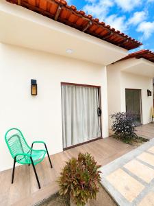 a green chair sitting on a porch of a house at Casa Dona Amélia in Barreirinhas