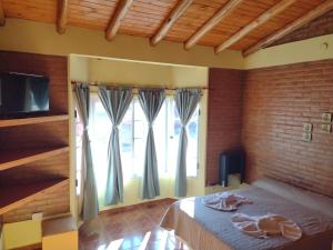 a bedroom with a bed and a large window at Cabañas Mi Atardecer in Nono