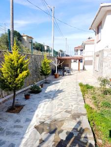 a patio with trees and a stone wall at Gökçeada Chrysi Petra pansiyon in Gokceada Town +23 photos