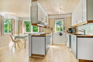 a large kitchen with white cabinets and a table at 30061-Malling-Morbaervaenget-18 in Malling +17 photos