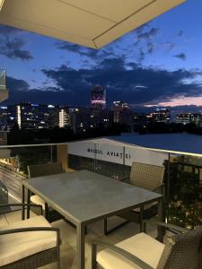a table on a balcony with a view of the city at PREMIUM Apartament & Wellness with jacuzzi, sauna , gym , pool in Bucharest
