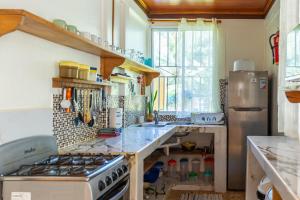 a kitchen with a stove and a refrigerator at Our Beachfront Bungalow in Puerto Viejo