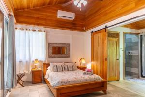 a bedroom with a bed with a wooden ceiling at Our Beachfront Bungalow in Puerto Viejo