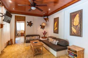 a living room with a couch and a ceiling fan at Our Beachfront Bungalow in Puerto Viejo