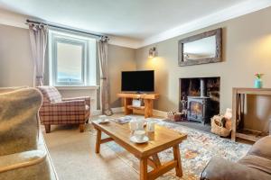 a living room with a couch and a tv and a table at 2 Bed in Strath oc-s44223 in Gairloch