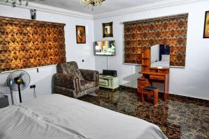 a bedroom with a bed and a chair and a desk at Lodgeselect in Ibadan +144 photos