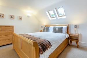 a bedroom with a wooden bed and two windows at 2 Bed in Strath oc-s44223 in Gairloch