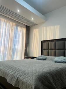 a bedroom with a large bed with blue pillows on it at PREMIUM Apartament & Wellness with jacuzzi, sauna , gym , pool in Bucharest