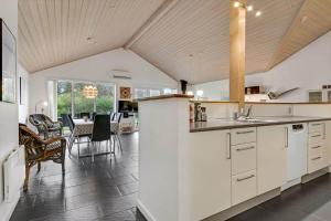 a kitchen with white cabinets and a table with chairs at C11331-Tarm-Brombaervej-5 in Tarm