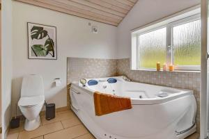 a bathroom with a white tub and a toilet at C11331-Tarm-Brombaervej-5 in Tarm +38 photos
