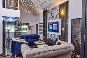 a living room with two couches and a tv at Lodgeselect in Ibadan
