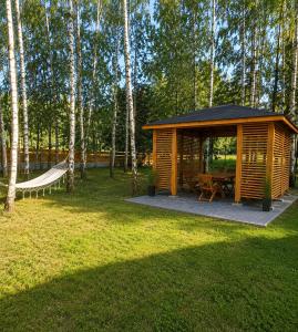a wooden cabin with a hammock in a park at Wypoczynek "POD BRZÓSTKAMI" in Nagłowice