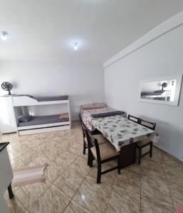 a room with a table and a bench and a bed at Hotel Parque Mamed in Diadema