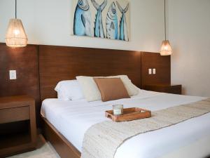 a bedroom with a bed with a tray on it at La Palma Beachfront Hotel Boutique in Cancún +6 photos