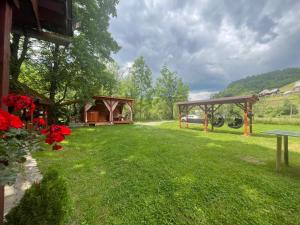 a garden with a gazebo and a picnic shelter at Cabana Paltini in Costeşti