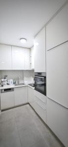 a white kitchen with white cabinets and appliances at Apartman Doboj in Doboj