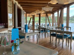 a restaurant with tables and chairs with a view of the water at Sizigia in Castro