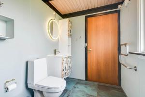 a bathroom with a toilet and a wooden door at C11704-Hemmet-Rylevaenget-33 in Hemmet +30 photos